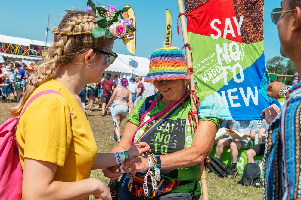 A campaigner helps put a wrist band onto a festival goer at Glastonbury festival in 2019.