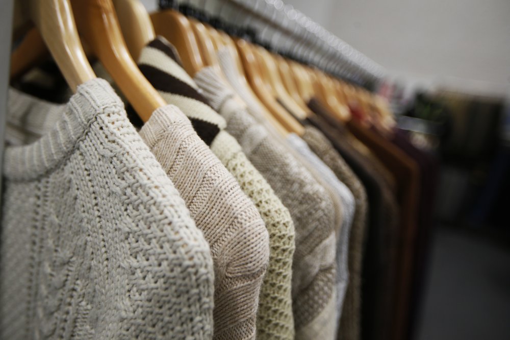 Grey knitwear on a clothes rail