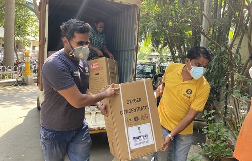 Oxfam staff Nikhil Wagh and Parmeshwar Patil carrying oxygen concentrator during delivery to Yashwantrao Chavan Memorial Hospital (YCM Hospital).