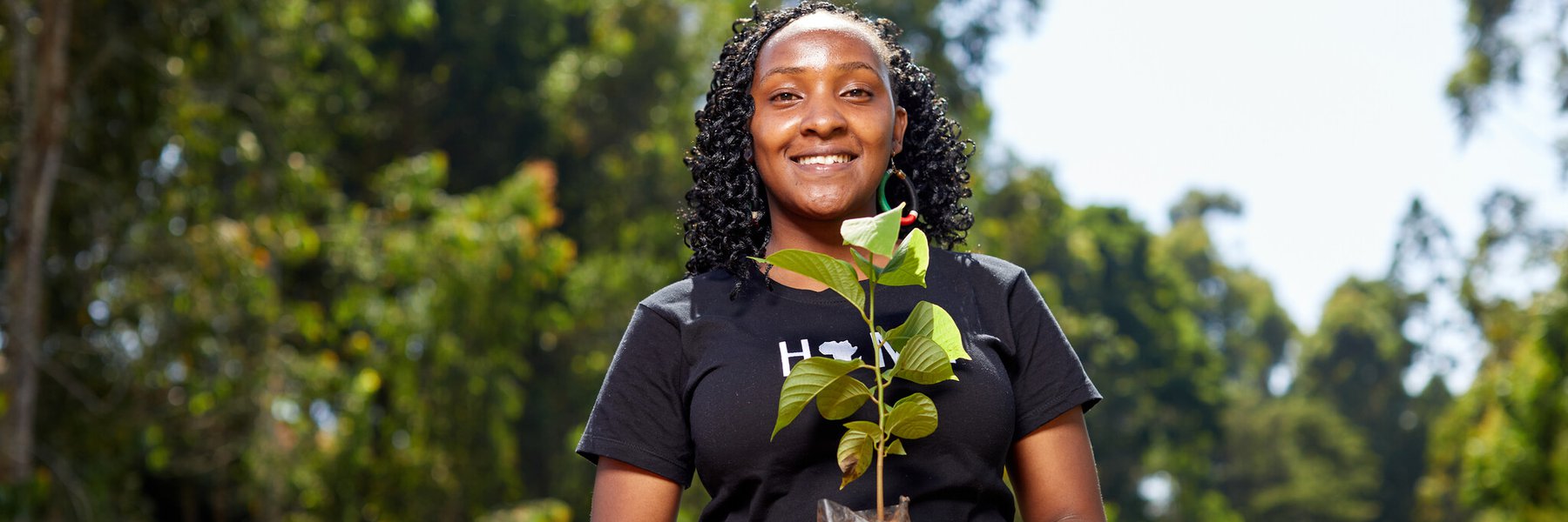 Climate activist and youth leader Elizabeth holds a sapling. Credit: Armstrong Too