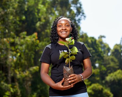 Climate activist and youth leader Elizabeth holds a sapling. Credit: Armstrong Too
