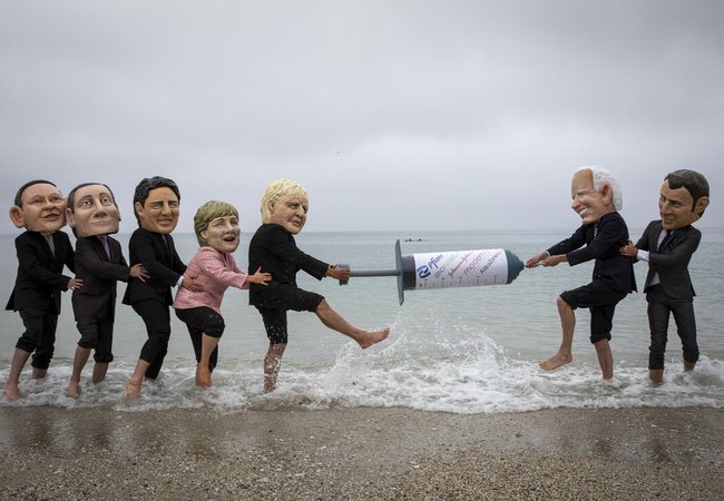 Campaigners from Oxfam and The People’s Vaccine Alliance pose as world leaders at the G7 summit in Cornwall, 2021.