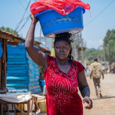 Joyce Nyarangi Oyogi carries a basin on her head with dirty laundry in Kibarage, Nairobi, Kenya.