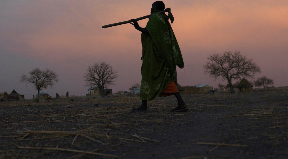 Tereza, 38, walks home at dusk from her farm in Renk, South Sudan.
