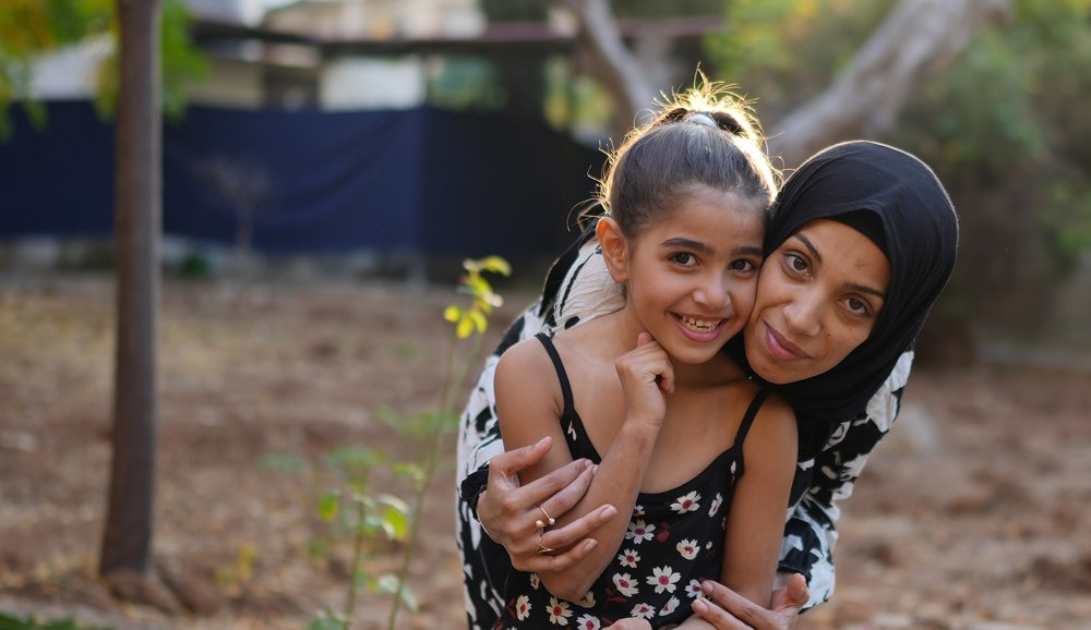 Siham, a displaced woman from Lebanon, with her 7-year-old daughter, after undergoing eye surgery