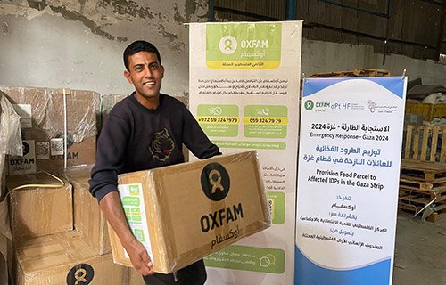 An Oxfam community member receiving a food parcel for Oxfam in Gaza City.