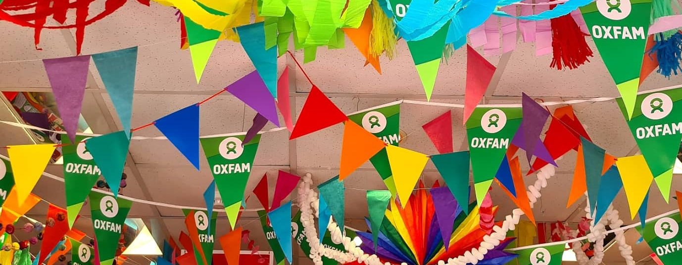 Inside the Oxfam Brighton shop during Pride month with loads of rainbow streamers and bunting