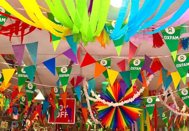 Inside the Oxfam Brighton shop during Pride month with loads of rainbow streamers and bunting