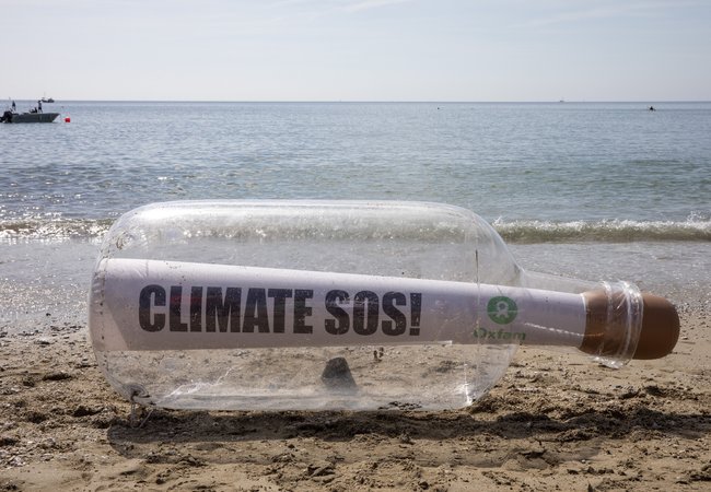 A giant message in a bottle reading Climate SOS has washed up on the beach