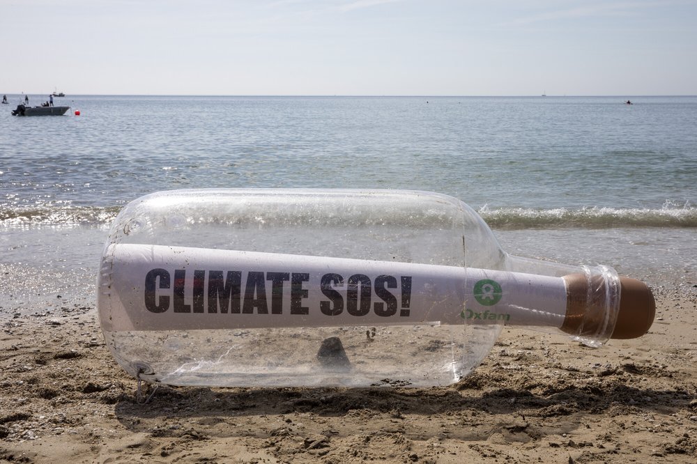 A giant message in a bottle reading Climate SOS has washed up on the beach