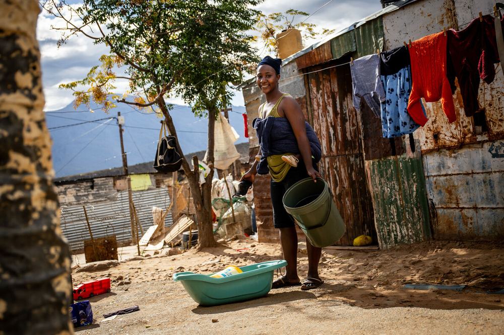 Primrose Mulenga, 25, hangs laundry in the front yard of her home in the informal settlement in De Doorns, South Africa.