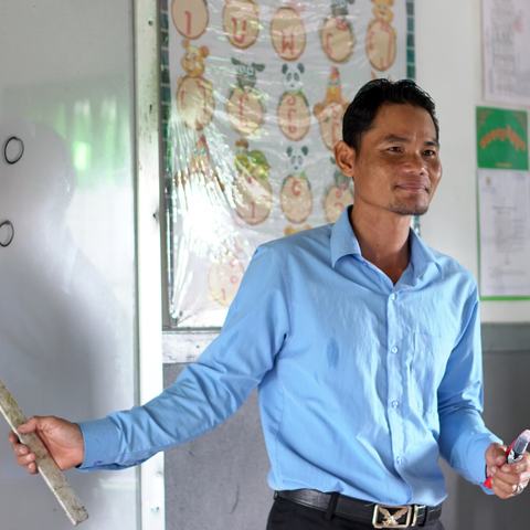 Vuthy, the director of the primary school in Cambodia, standing in front of the class.