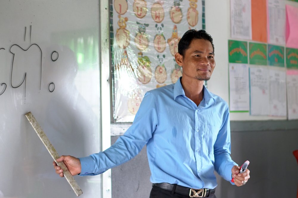 Vuthy, the director of the primary school in Cambodia, standing in front of the class.