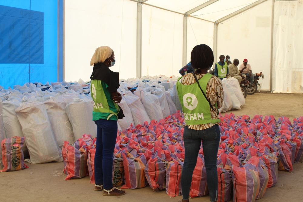 Oxfam staff in a tent in N'djamena, Chad looking at bags of food before distribution to the local community