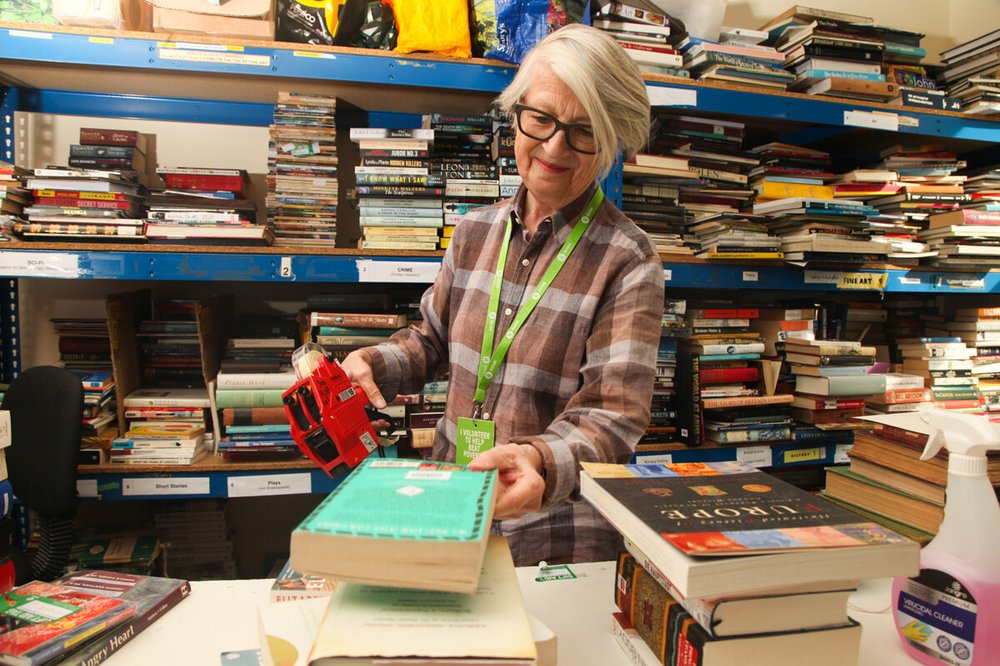 Volunteer Kathryn prices up books in the stockroom at Oxfam's Islington Bookshop.