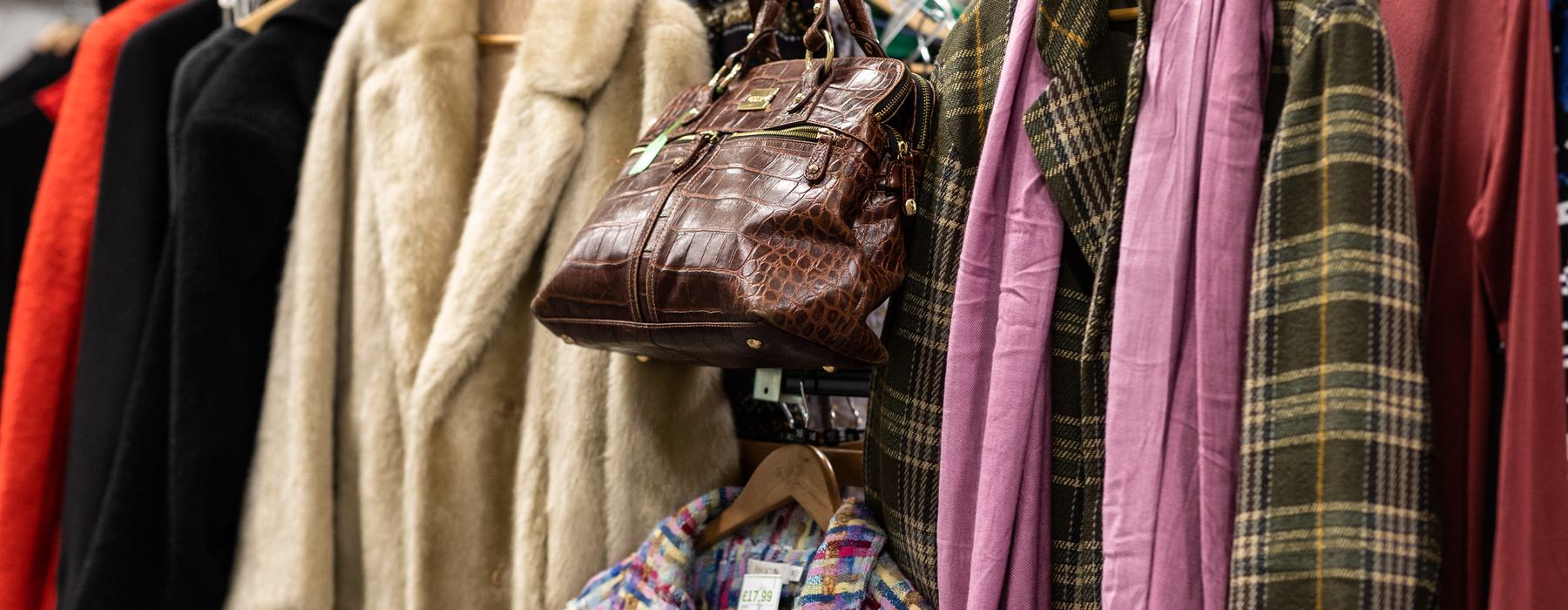 A fashionable clothing rail with coats and bags.