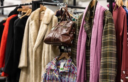 A fashionable clothing rail with coats and bags.