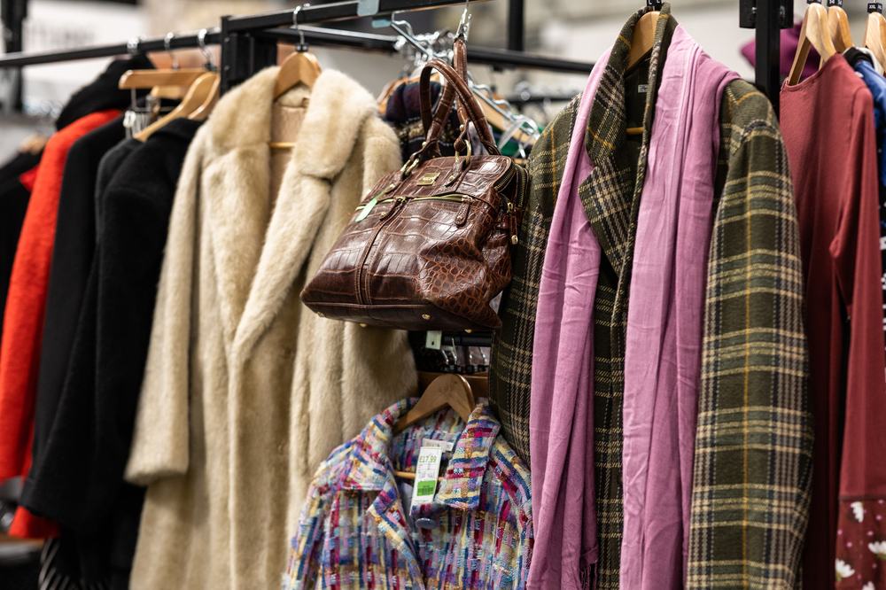 A check coat with pink scarf, a fur coat, a croc bag.