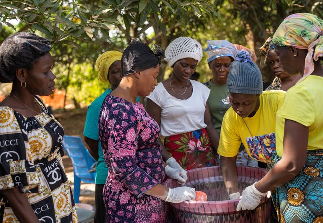 Magdalene Bangura (centre), the leader of Female Pastors Network (FEMINET) leads the gari making process at her home in Port Loko, Sierra Leone.