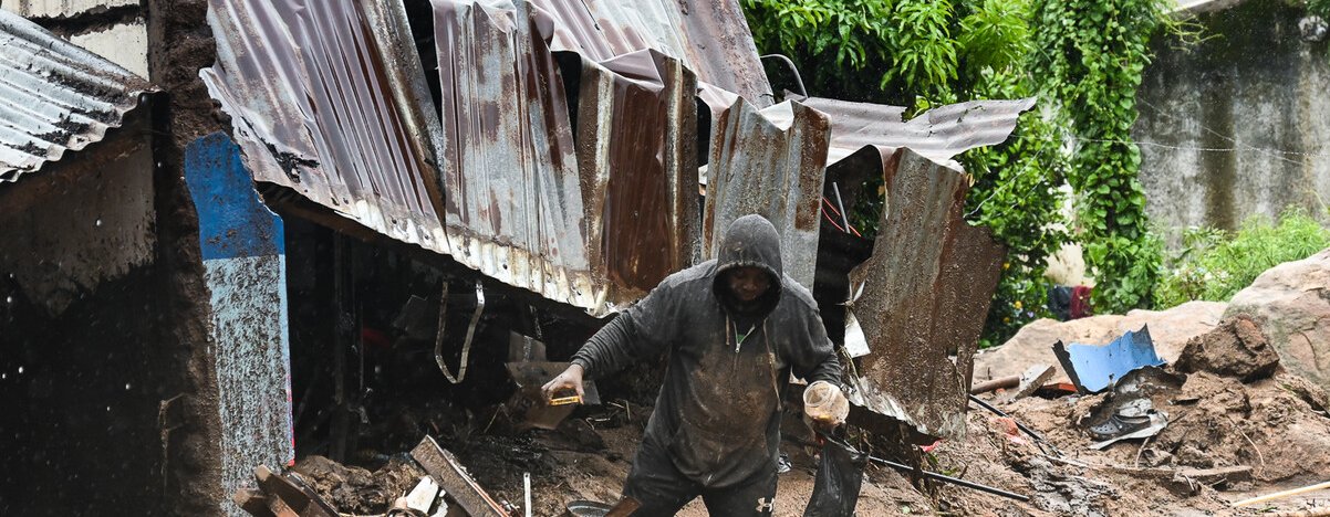 A man in Chilobwe Township in Blantyre picking something from the rubble of his house after mudslides, heavy rains and winds destroyed it