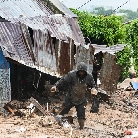 A man in Chilobwe Township in Blantyre picking something from the rubble of his house after mudslides, heavy rains and winds destroyed it