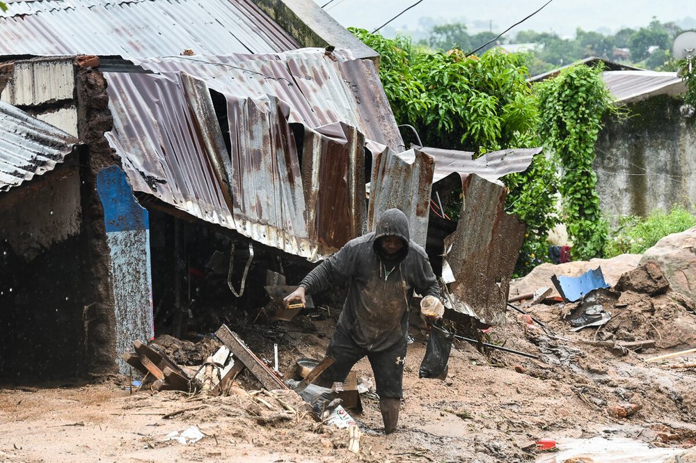 A man in Chilobwe Township in Blantyre picking something from the rubble of his house after mudslides, heavy rains and winds destroyed it