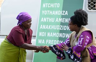 Oxfam Malawi Country Director Linga Mihowa hands a cash donation to 65-year-old Ligineti Nayinayi, a Cyclone Freddy survivor in Phalombe, southern Malawi