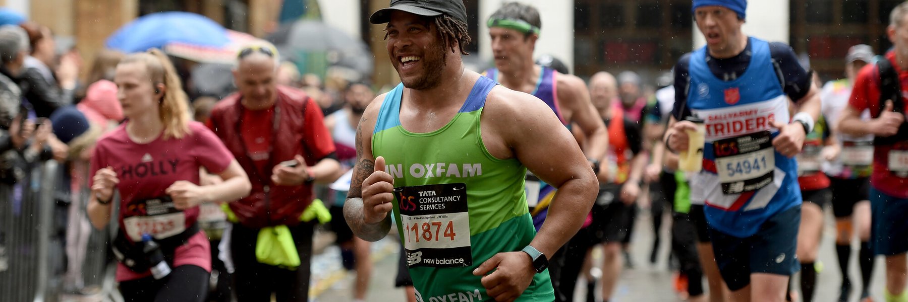 A man running and smiling at the 2023 London Marathon.