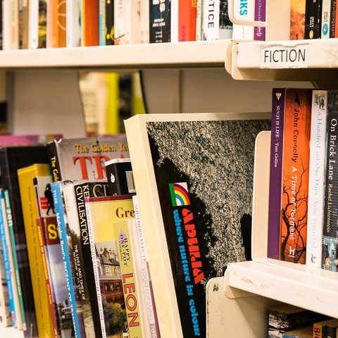 A shelf of donated books on display in Oxfam's Brighton & Hove bookshop.