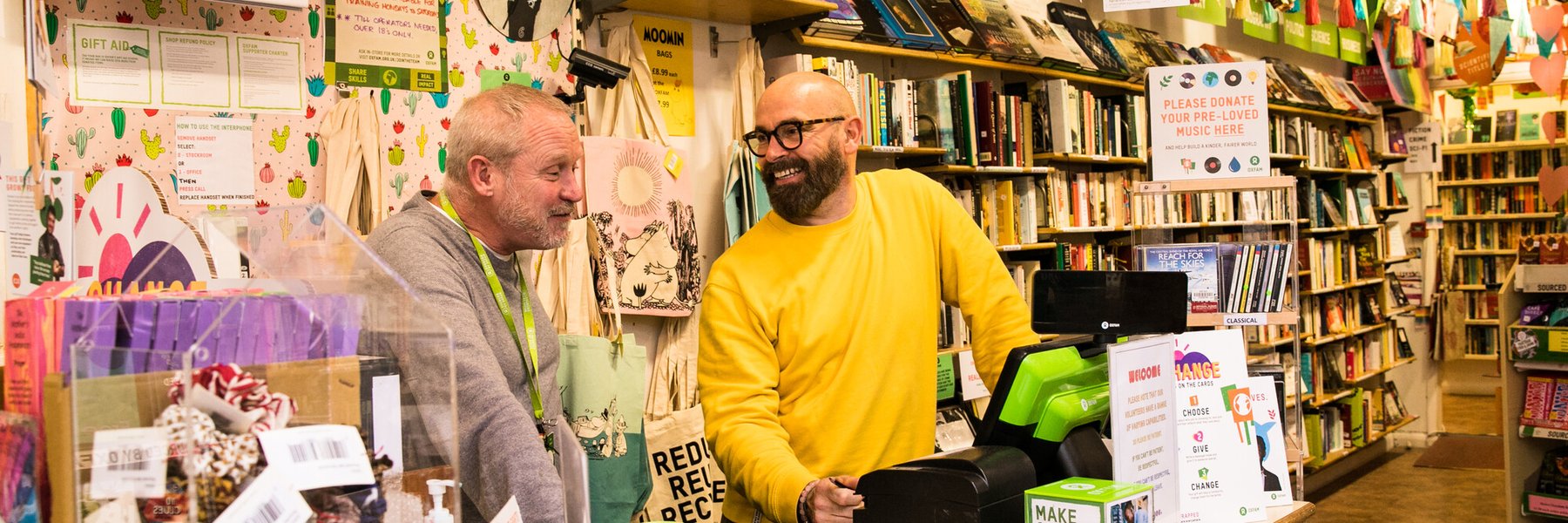 Volunteer Jeff and Shop Manager Scott at the counter in Kensington Garden's Bookshop in Brighton.