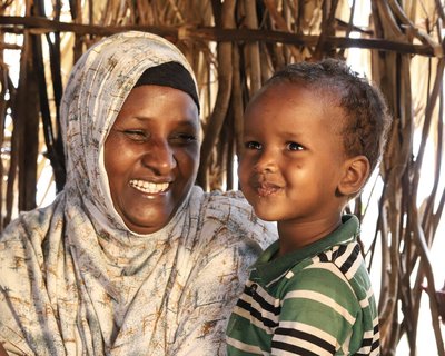 Abdia Ibrahim in Isiolo county, Kenyam drinks water with her son.