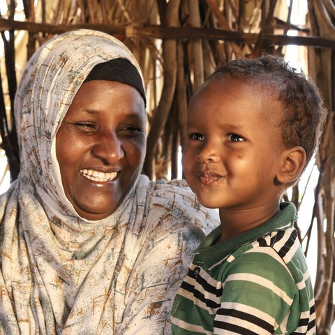 Abdia Ibrahim in Isiolo county, Kenyam drinks water with her son.