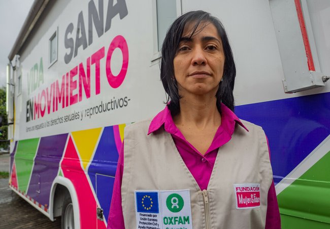Johanna, a woman in an Oxfam-branded jacket, faces the camera as she stands outside a mobile reproductive health clinic in Columbia.