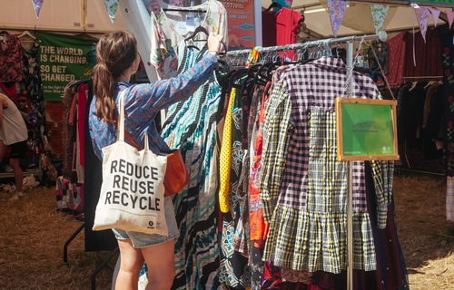 A woman browses second hand clothes at an Oxfam festival shop at Glastonbury 2023.