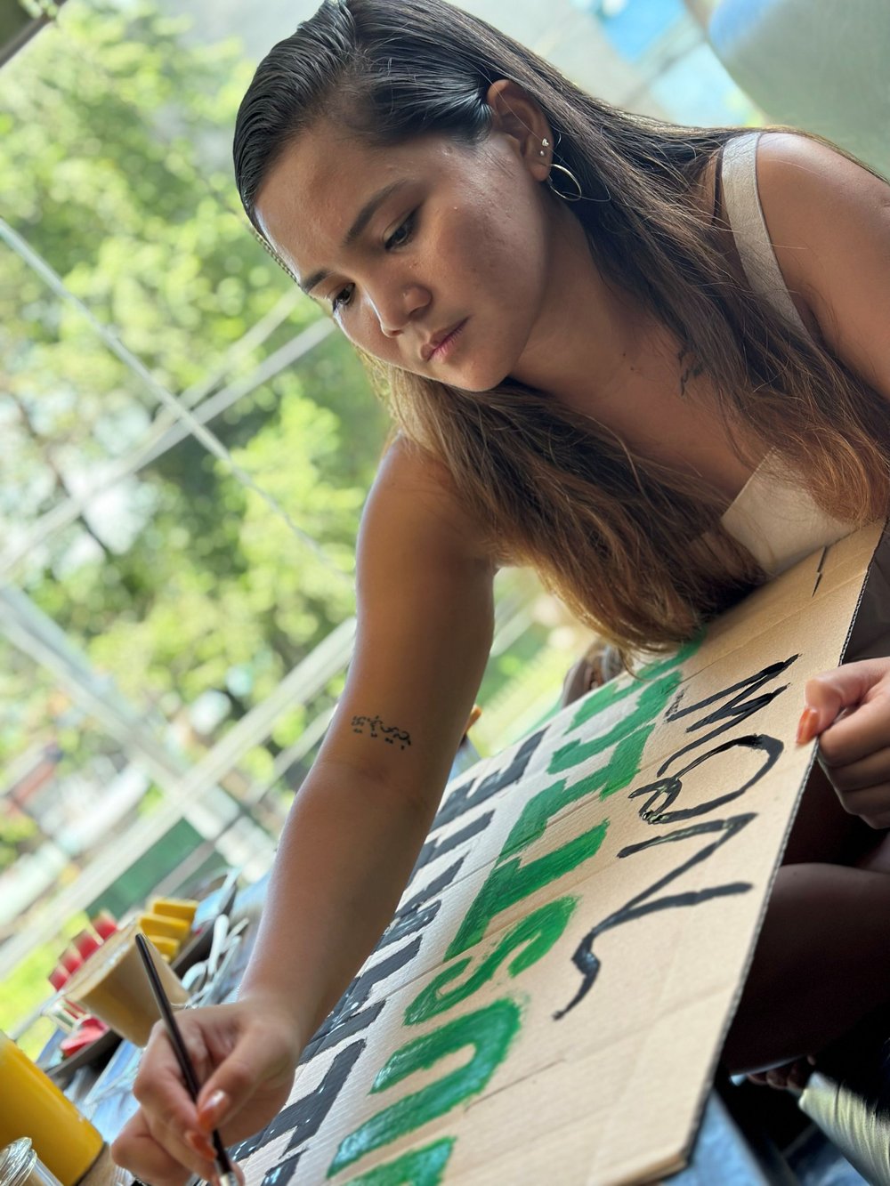 Marinel Ubaldo painting a climate justice placard