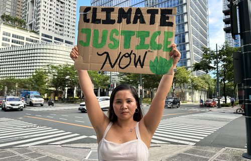 Marinel holding up her climate justice placard
