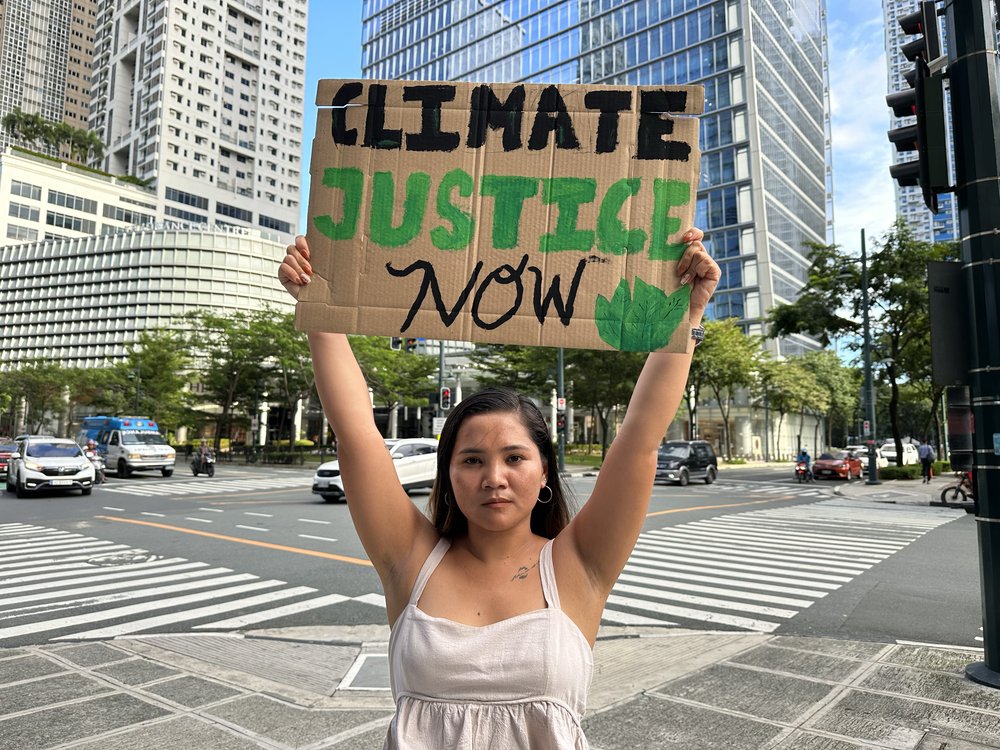 Marinel holding up her climate justice placard
