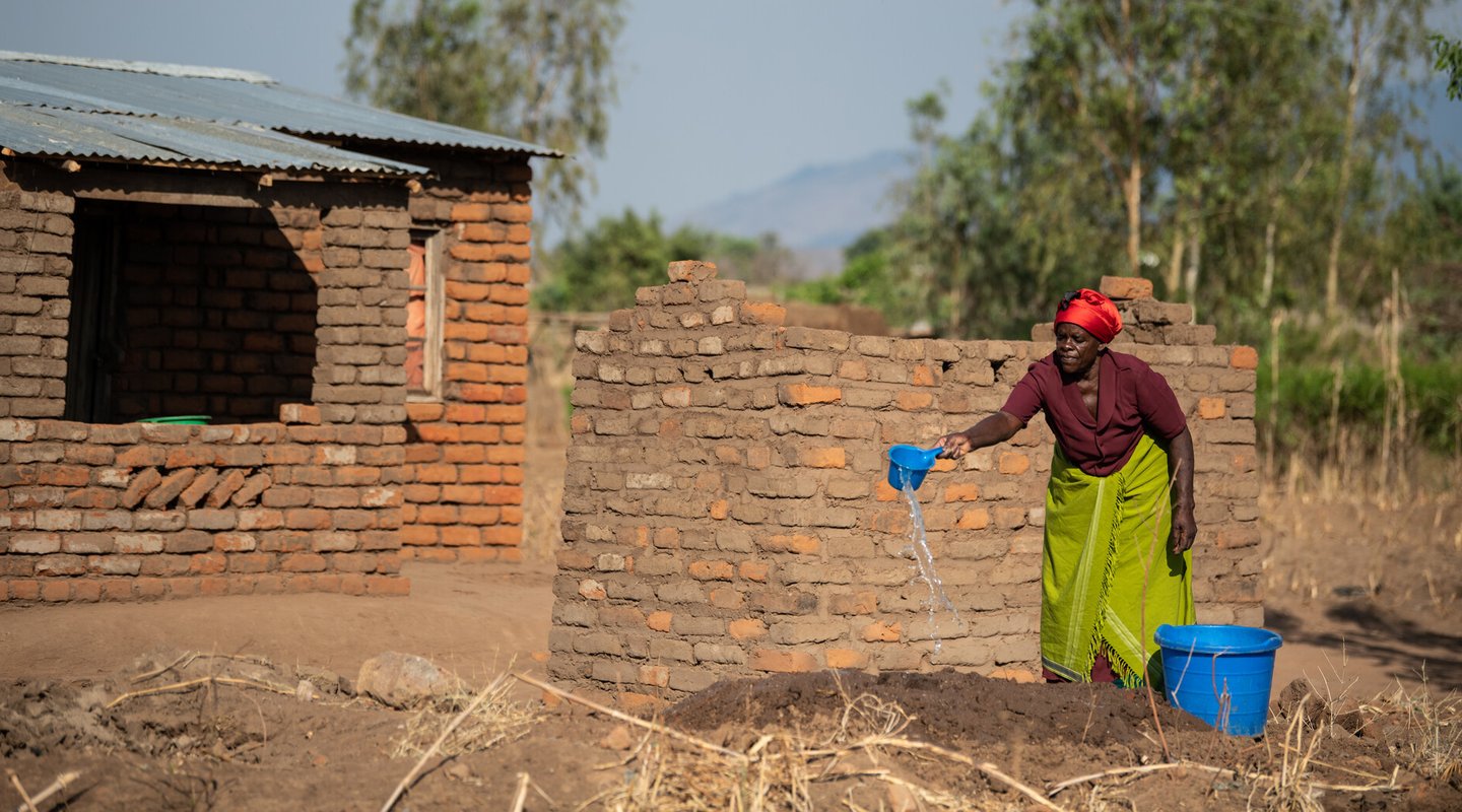 Ligineti watering mud for making bricks at her village in Phalombe, southern Malawi