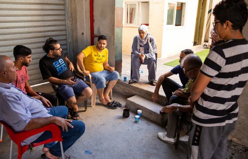 Huwaida sits in a circle with other members of the shelter where she works in Gaza.