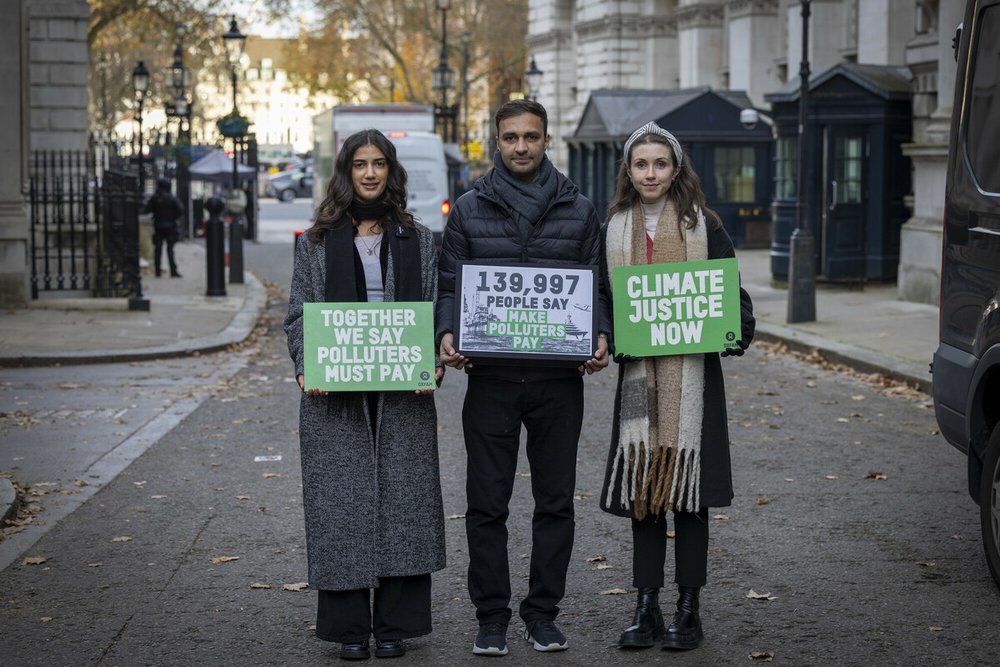 Oxfam petitioners hold signs in Downing Street.