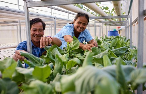 Chana and Sare care for plants in their aquaponics greenhouse in Sambo, Cambodia.