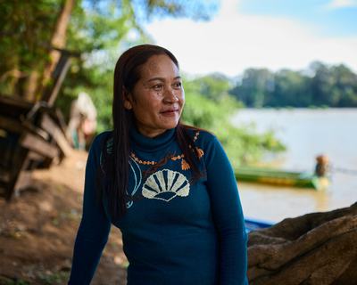 Siphon sitting on a fallen tree looking out across the Mekong River near her village.