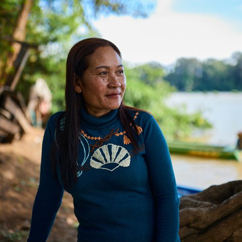 Siphon sitting on a fallen tree looking out across the Mekong River near her village.