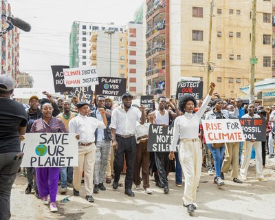 Protesters carry banners with messages like 'Save Our Planet' and 'Climate Justice' during a climate march in a city.