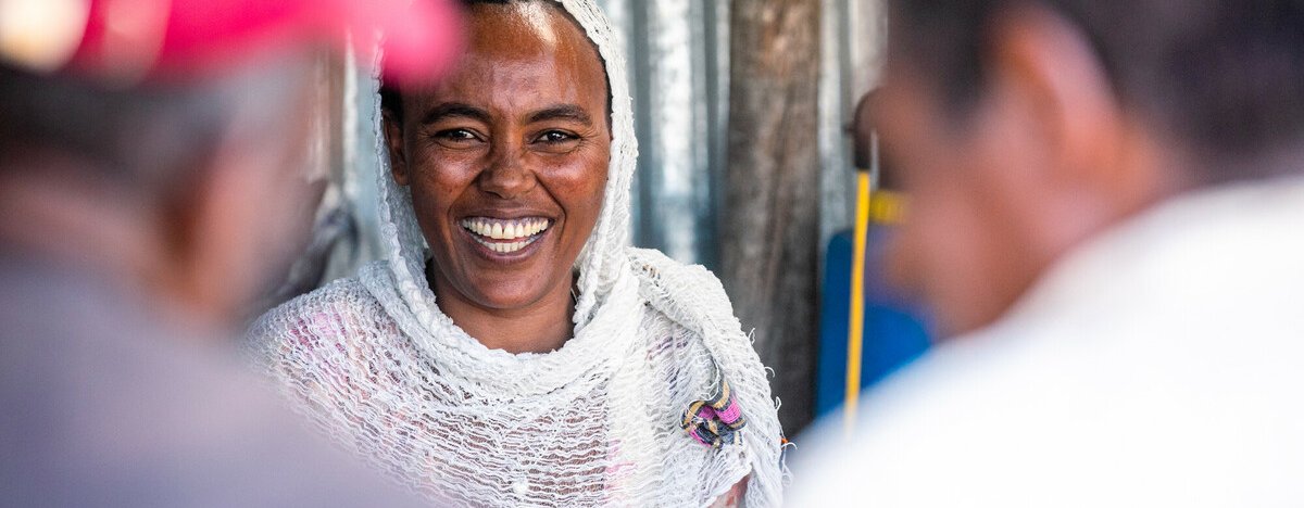 Mihret, a woman from Tigray in Ethiopia, smiles as she serves customers at her shop.