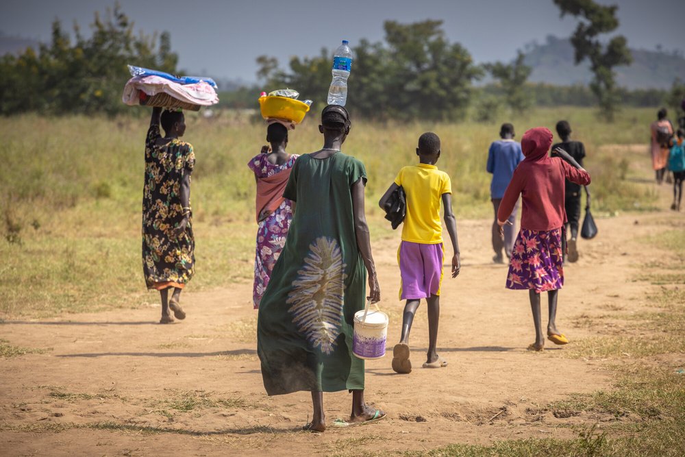 Refugee families from Gambella refugee camp in Ethiopia walking home after spending the day working at the market.