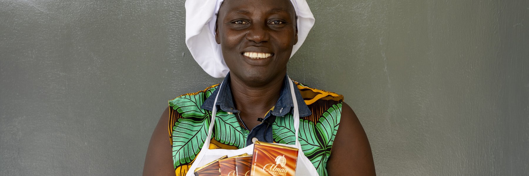 Leticia, the founder of the first ladies-only cocoa cooperative in Ghana, holds up some of the chocolate she has made.