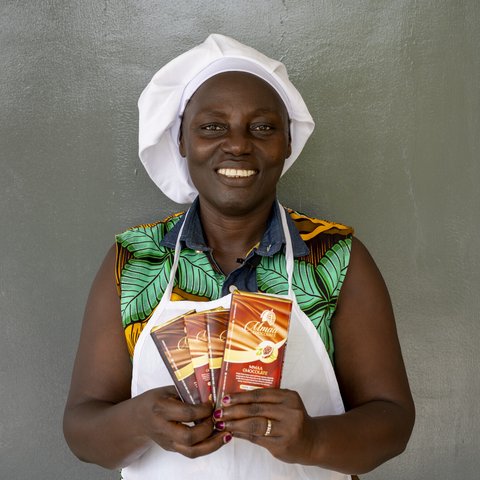 Leticia, the founder of the first ladies-only cocoa cooperative in Ghana, holds up some of the chocolate she has made.