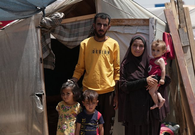 Duaa Abu Sabha is standing in front of her tent in the Al-Mawasi Area in Khan Yunis Governorate, Occupied Palestinian Territory.