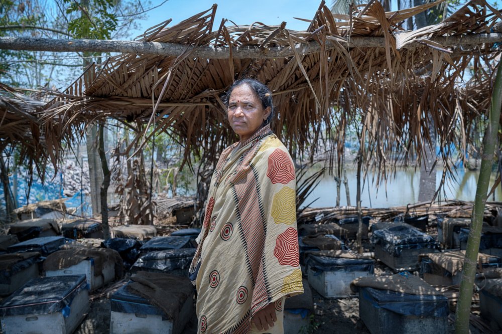 A woman in Bangladesh standing in front of her honey farm